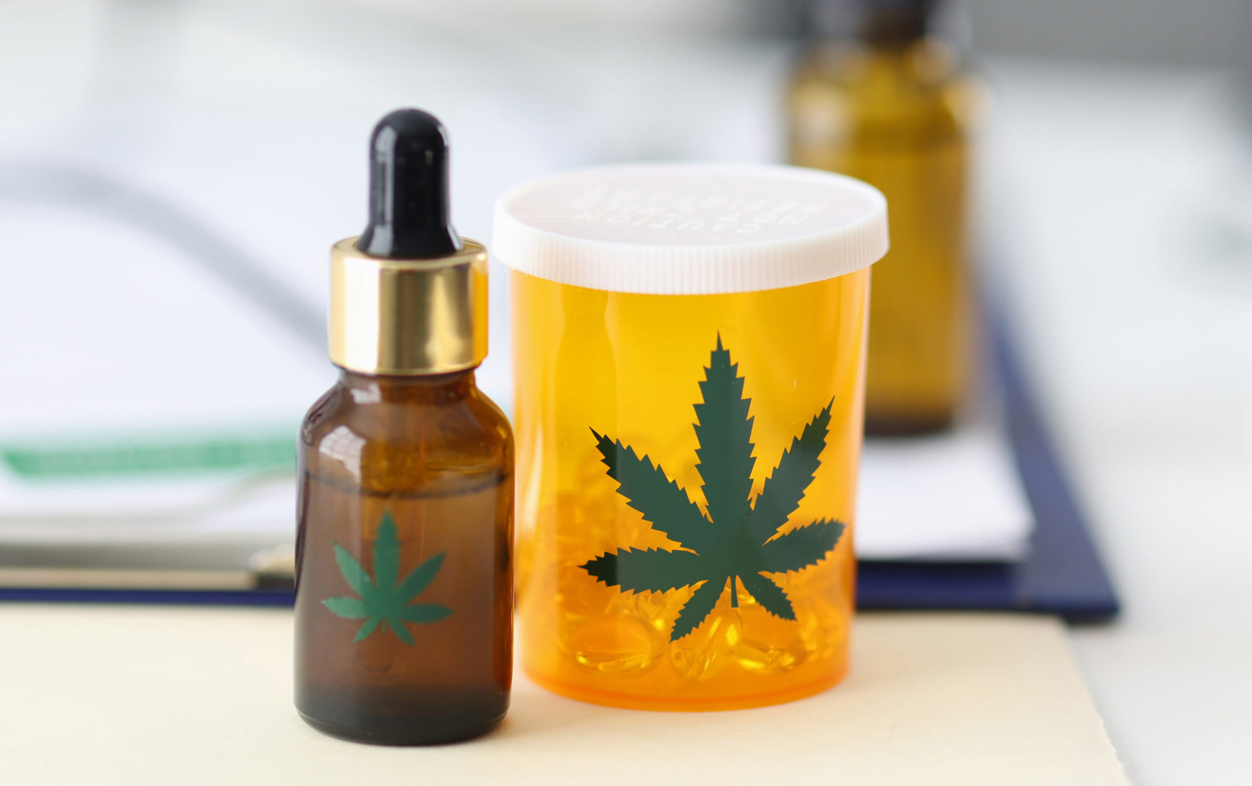 Jar of pills and marijuana extract are on doctors table in clinic closeup