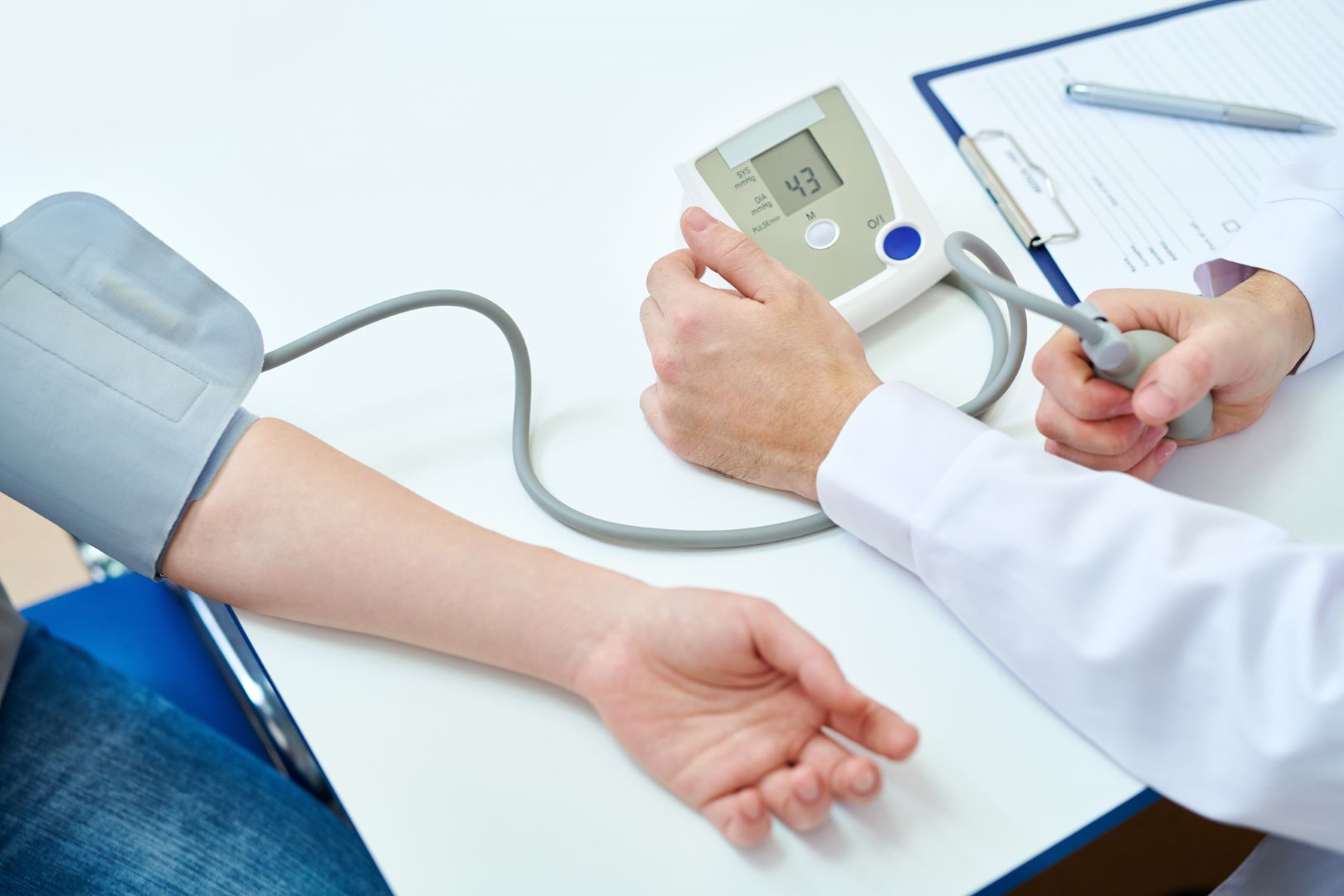 Closeup photo of a doctor measuring blood pressure using tonometer in office